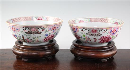 A pair of Chinese famille rose bowls, Qianlong period, 23.3cm, some faults, wood stands